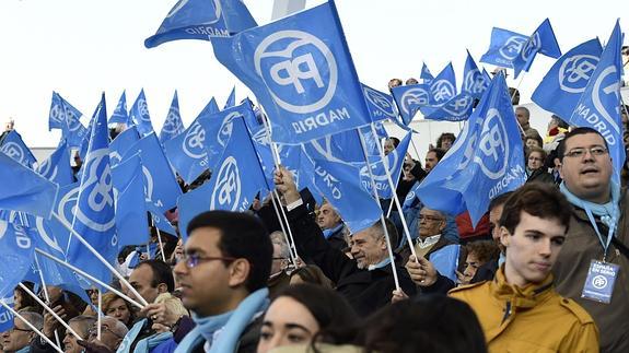 Militantes y seguidores del PP enarbolan banderas del partido durante un mitin en Las Rozas. 