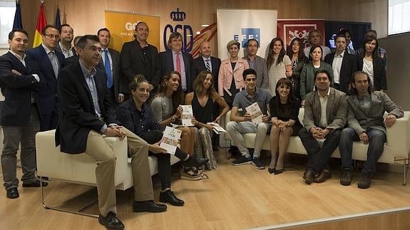 Los autores del libro posan con varios deportistas. 