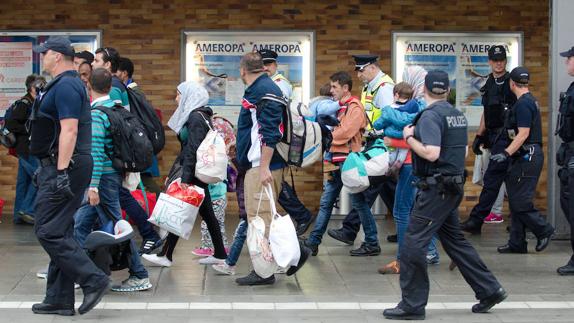 Refugiados son escoltados por la policía alemana a su llegada a la estación central de Munich, en septiembre de 2015. 