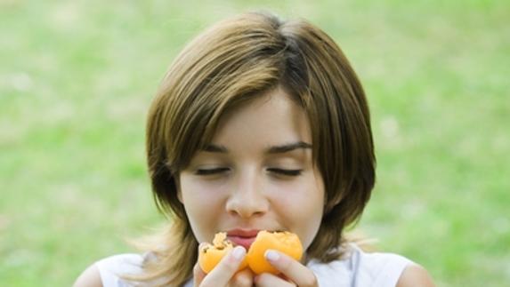 Una chica preparada para comerse una fruta, un hábito saludable.