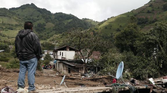 Un hombre observa desde el techo de lo que fuera una casa que quedó enterrada.