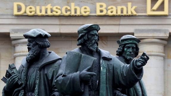 Una estatua frente al logo de Deutsche Bank.