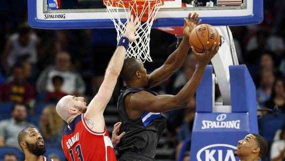 Serge Ibaka lanza ante la oposición de Marcin Gortat. 