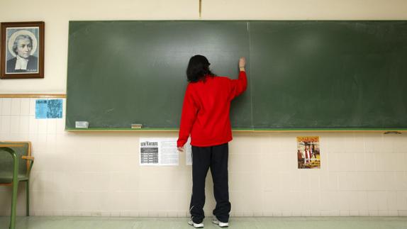 Un estudiante escribe en la pizarra de un colegio de Burgos. 
