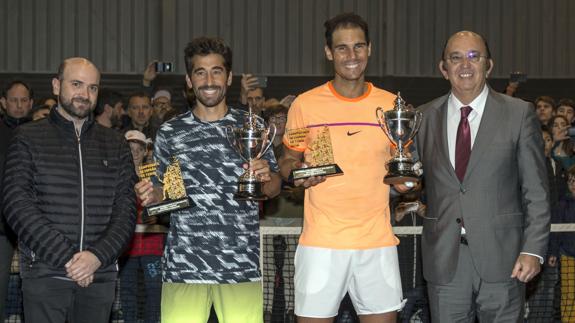Marc López y Rafa Nadal recogen el trofeo que les acredita como campeones. 