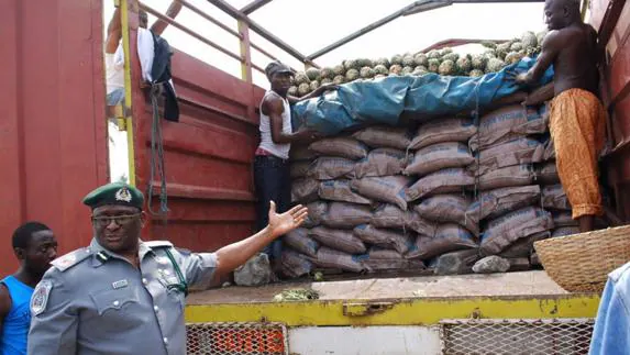 Policías nigerianos confiscan arroz de plástico tras su importación en Lagos.