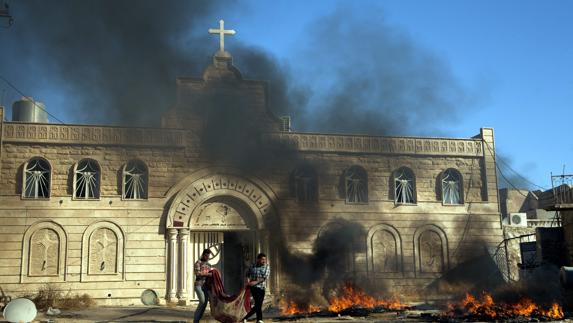 Voluntarios cristianos participan en labores de limpieza en la iglesia Mar Korkeis de Bashiqa (Irak).