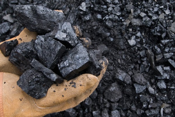 Un trabajador recoge varios trozos de mineral.