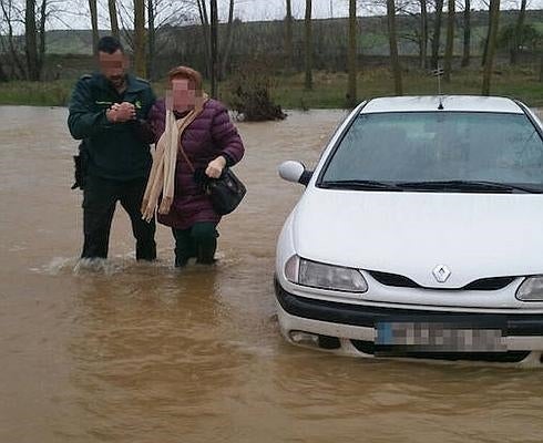 Un agente de la Guardia Civil rescate a una de las ocupantes del vehículo