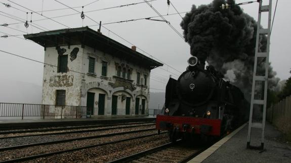 Una vieja máquina de vapor pasa junto a la antigua estación de Pajares, en 2004. 