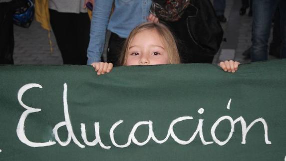 Una pequeña sostiene una de las pancartas de la manifestación por una educación de calidad.