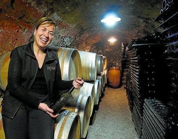 Berta Valgañón, con unas de las botellas que reposan en su histórico calado.