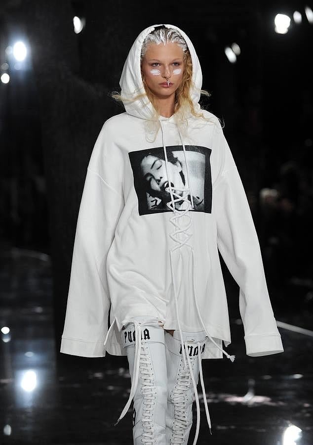 Sudadera blanca con capucha y botas altas con cordones.