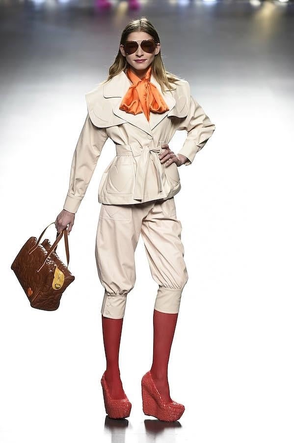 Pantalón y chaqueta de color beige combiando con medias y zapatos rojos.