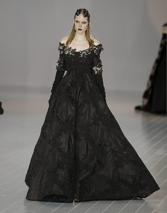 Un look de fiesta: vestido largo negro con bordados y adornos plateados en el escote y en las mangas.