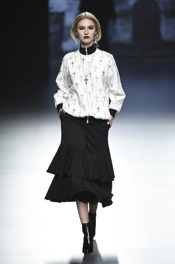 Sudadera blanca decorada con cruces y falda negra.