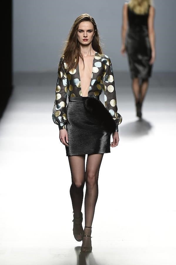 Blusa estampada con lunares y falda negra.