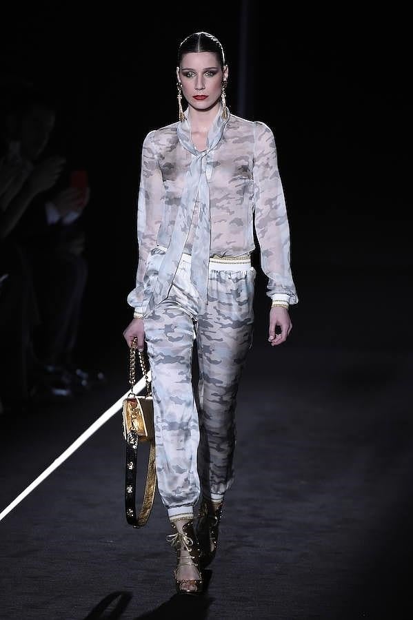 Pantalón y blusa con estampado militar con complementos dorados.