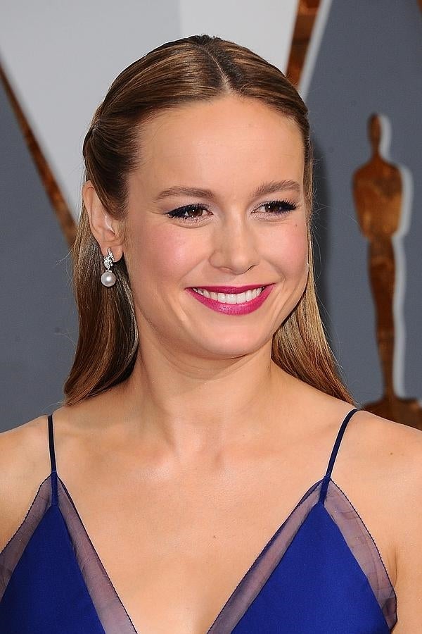 Brie Larson con semirrecogido con raya en medio y labios fucsias.