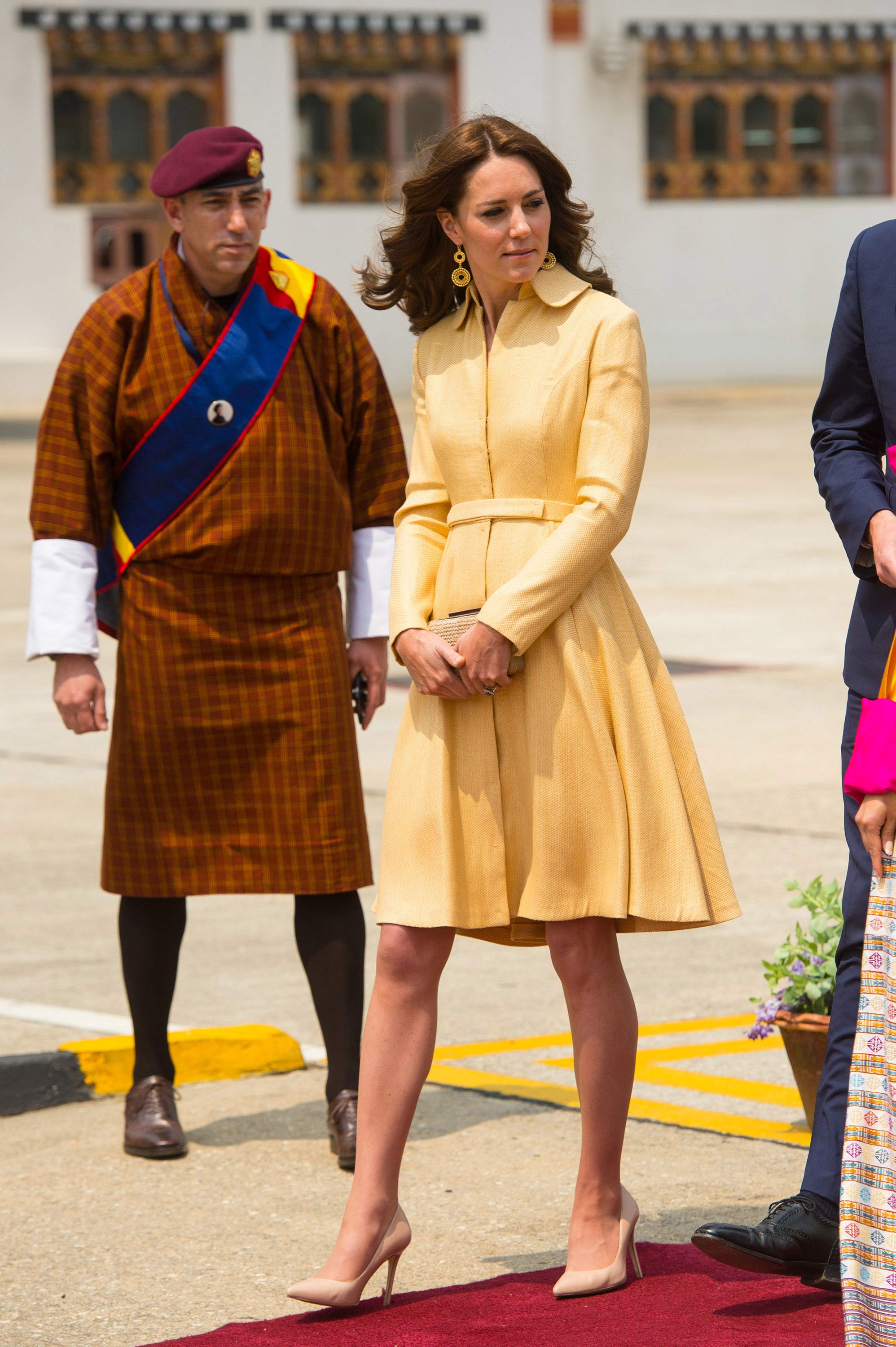 Cuando ha aterrizado en el país más feliz del mundo, la Duquesa de Cambridge ha aparecido con un elegante abrigo-vestido amarillo vainilla de la diseñadora Emilia Wickstead que estrenó en 2012, y que ha vuelto a combinar con su clutch de rafia y sus salones de LK Bennet.