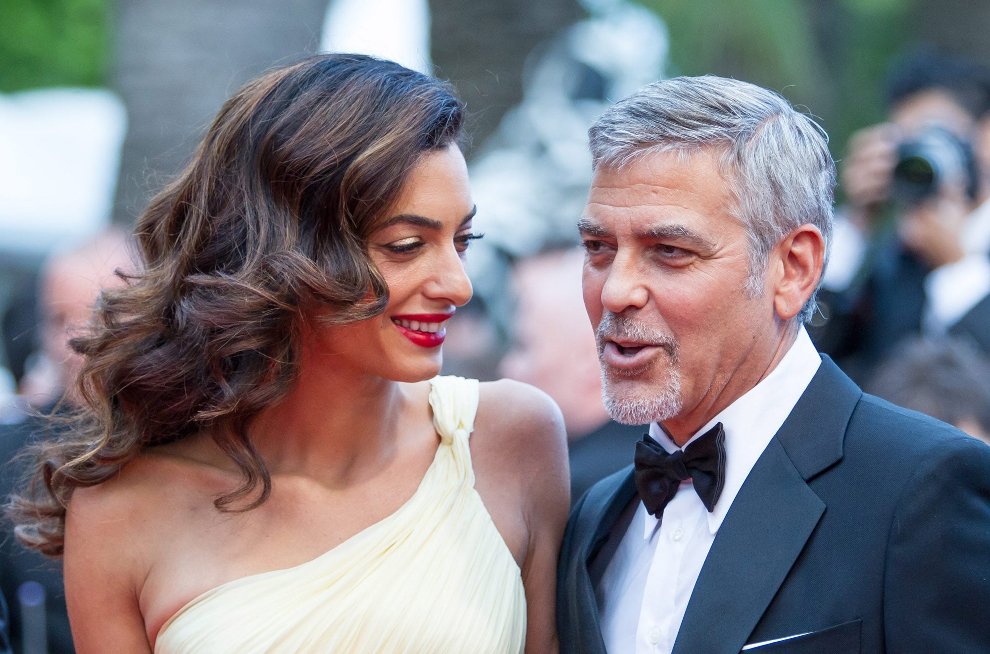 Fiel a su estilo, la mujer de George Clooney, posó junto a su marido, con melena suelta peinada con ondas marcadas y labrios rojos brillantes.