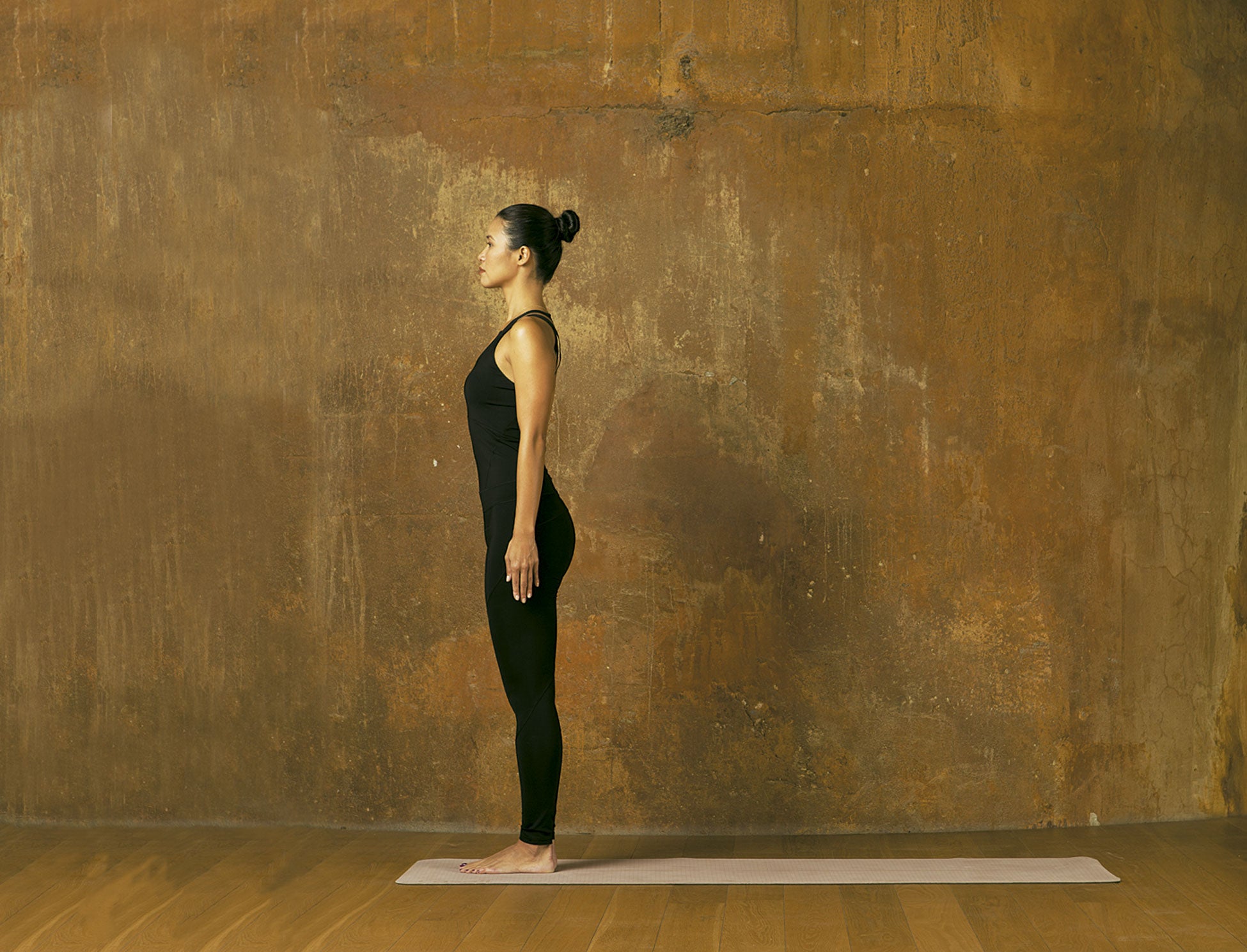 DE PARTIDA. Junta los pies y verifica que ambas piernas soportan el mismo peso. Lleva el coxis hacia delante y asciende las costillas flotantes. Mantén el mentón paralelo al suelo. Ensancha los hombros y coloca los brazos a los lados, en línea con las caderas. Mantén las postura durante tres respiraciones con los ojos abiertos y otros tres con los ojos cerrados. PALABRA DE ESXPERTA. Ejecutada correctamente esta postura estabiliza el cuerpo y fortalece los muslos, las rodillas, los tobillos, el abdomen y las nalgas.