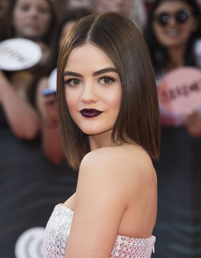 La actriz estadounidense Lucy Hale con long bob extra liso y peinado con raya en el medio.