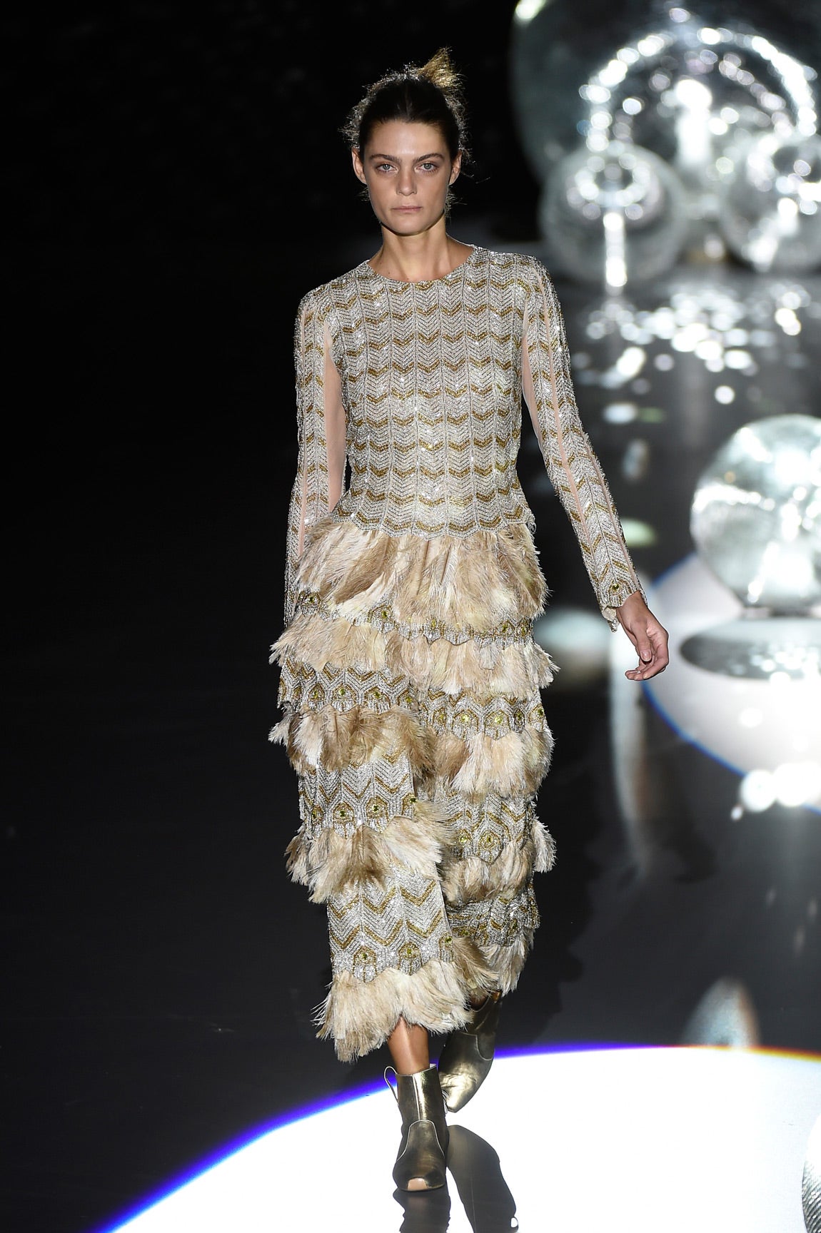 Vestido largo con lentejuelas en plateado y dorado y detalles de flecos en la falda del vestido.