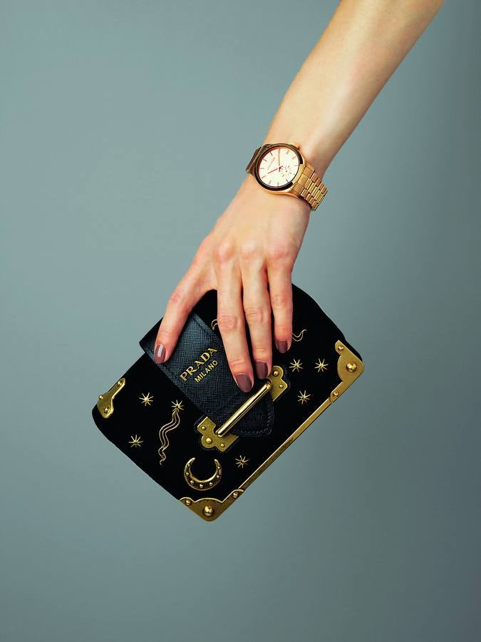 Reloj Hamptons, en acero con recubrimiento rosa en titanio y oro, de Aristocrazy; y bolso en piel y terciopelo con detalles metálicos, de Prada.