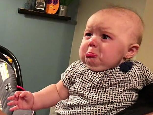 La pequeña Ella, haciendo pucheros mientras sus padres se besan.