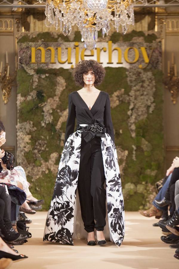 La diseñadora Carmen Halffter inauguró el desfile de Novias Couture de Mujerhoy con un original modelo de pantalón negro con sobre falda blanca con grandes motivos florales en negro.