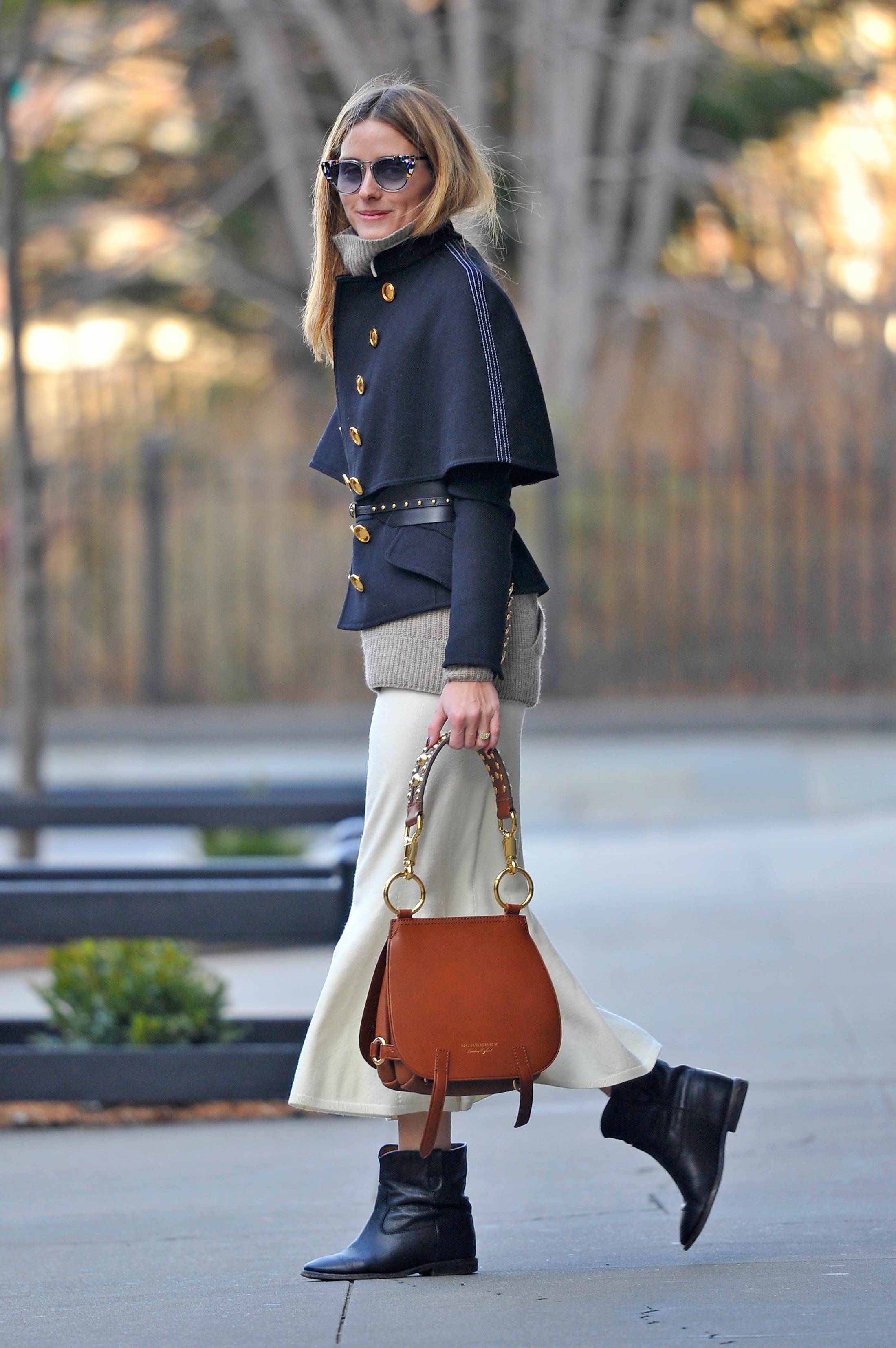 La 'it girl' nos deja en las calles de Nueva York uno de los mejores 'street styles' de la temporada. Olivia Palermo combina una falda midi de punto en color hueso con un jersey de lana oversize beige, abrigo-capa de inspiración militar de Burberry, bolso de cuero de la misma firma, botines bajos y gafas joya. ¿Puede haber una fórmula más perfecta?