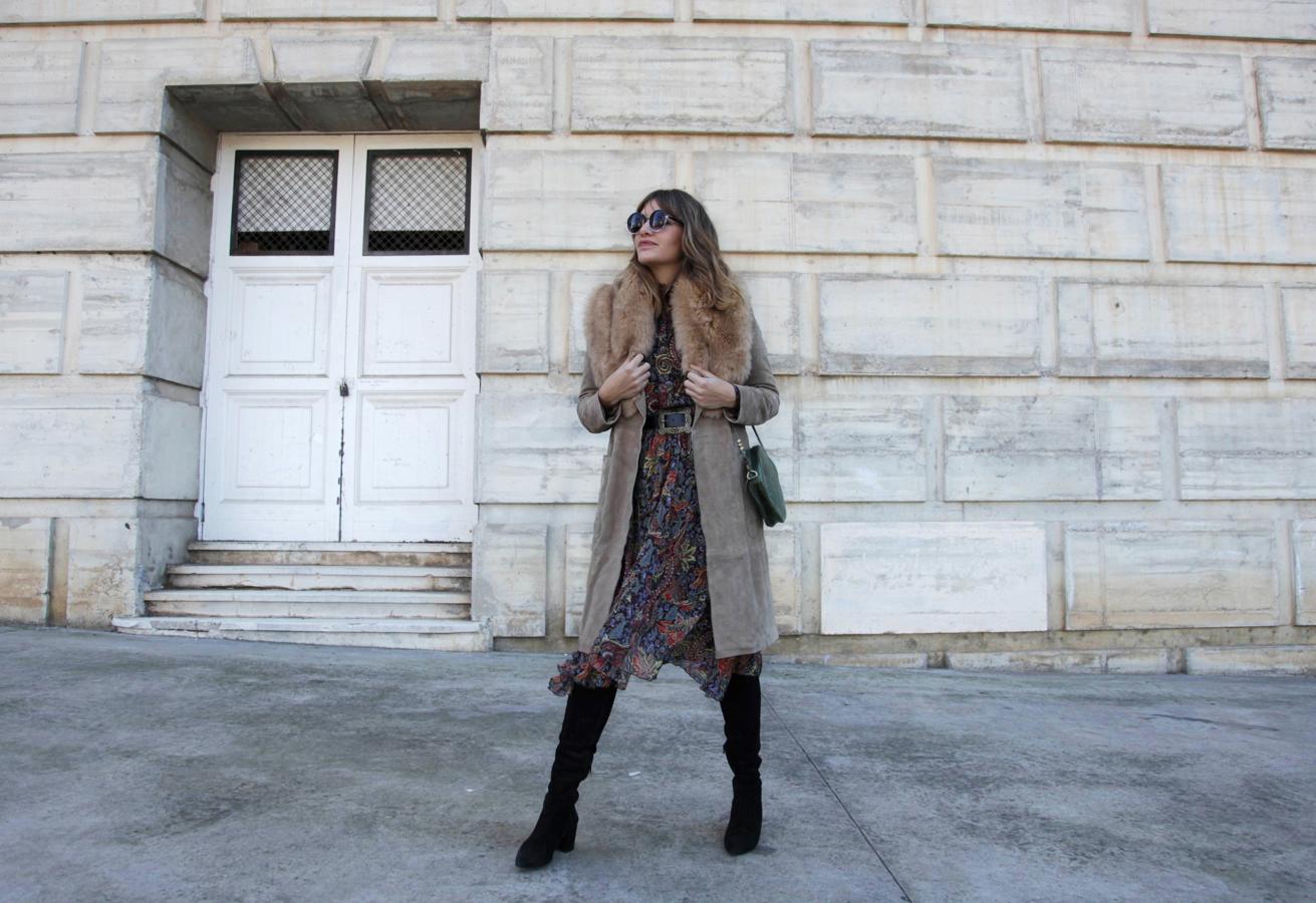 My Daily Style con abrigo con cuello de pelo, vestido con estampado paisley y botas altas.