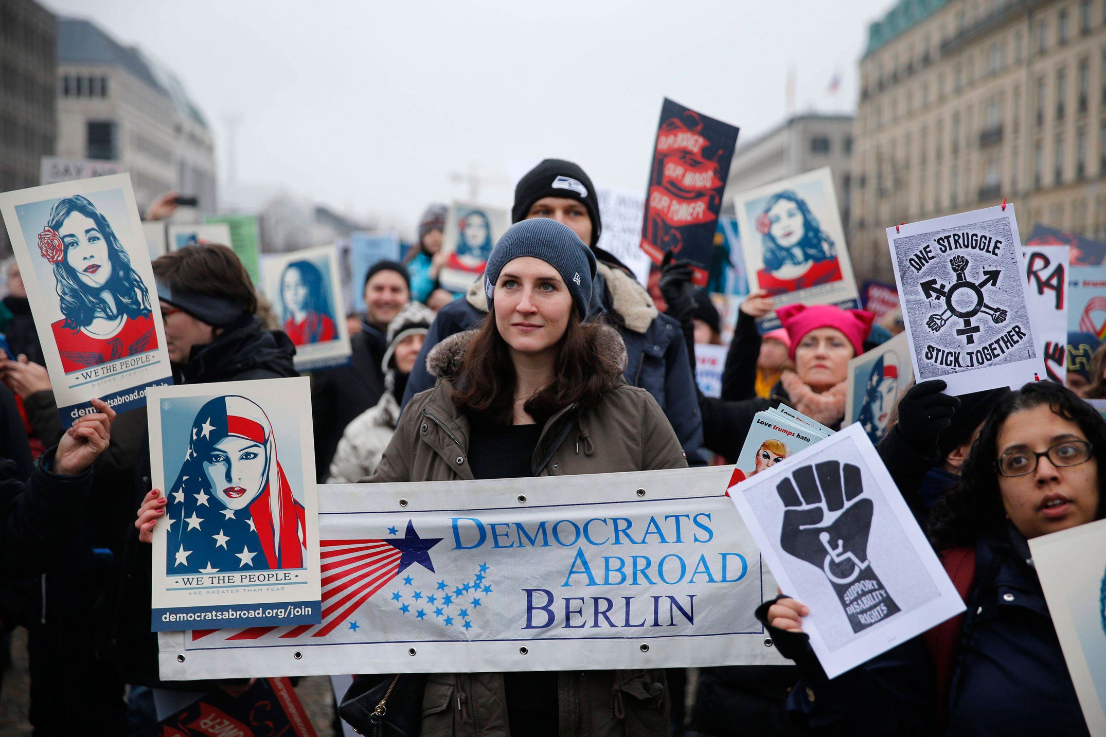 Mujeres en Berlín con carteles de diferentes mucjeres teñidas con los colores de la bandera americana bajo el lema: "Nosotros somos más fuertes que el miedo".