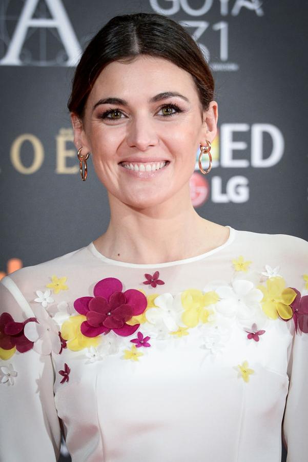 La actriz Marta Nieto con moño de bailarina con raya en el medio y un maquillaje muy luminoso, con sombras rosas y abundante máscara de pestañas, y labios naturales.