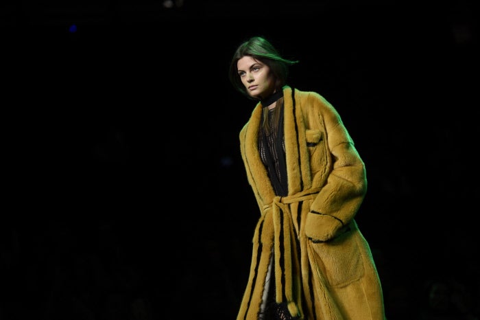 Los maxi abrigos de piel se pintan de colores vivos, como este mostaza que se combina con negro en una conjunción perfecta.