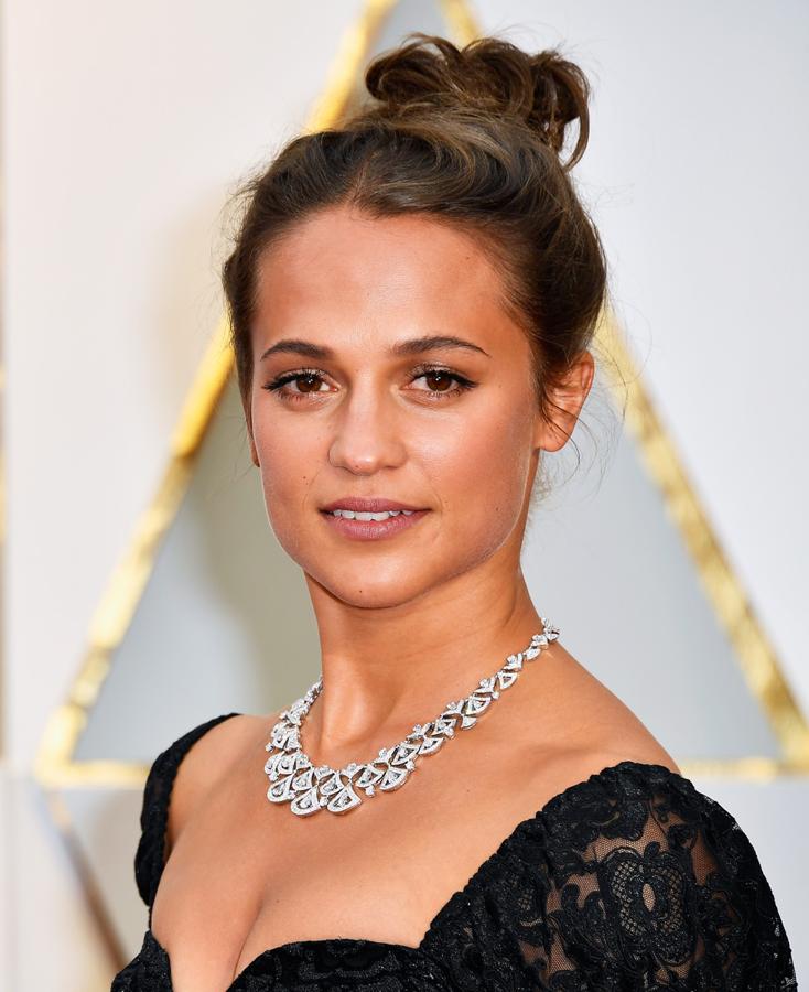 La actriz Alicia Vikander sorprendió con un moño alto desenfadado y un maquillaje en clave minimal y muy luminoso.