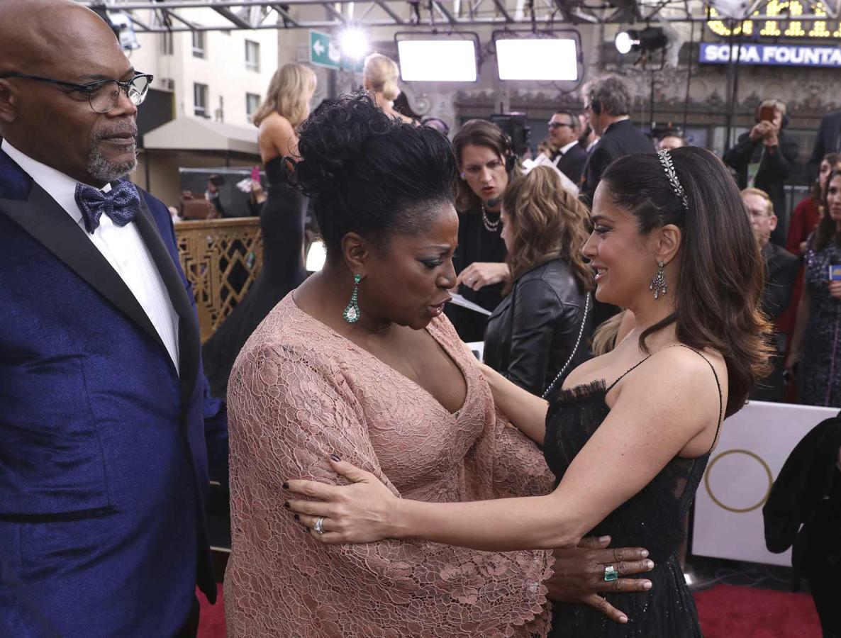 LaTanya Richardson, en presencia de Samul L. Jackson, comprueba que todo esté en su sitio en el escote de Salma Hayek.