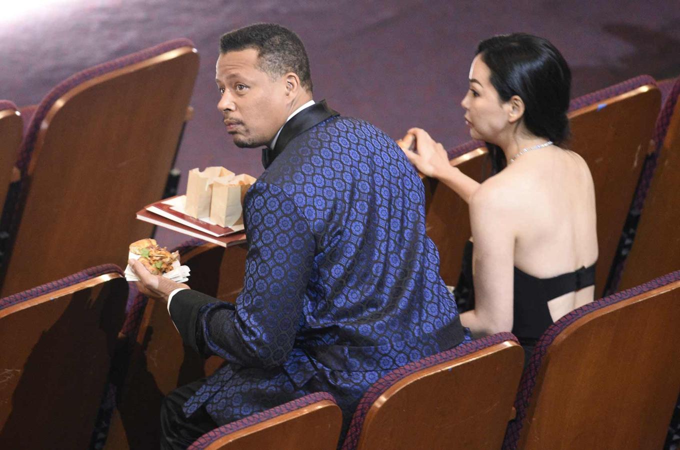 Terrence Howard y Miranda Pak picando algo a mitad de la gala.