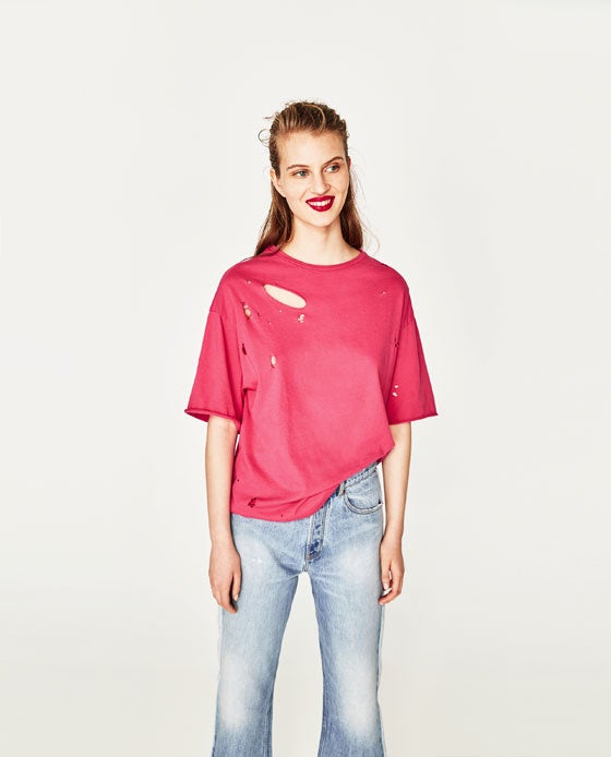 Camiseta rosa de manga corta con rotos de Zara. Precio: 12,95 euros.