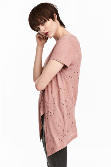 Camiseta con rotos asimétrica de H&M. Precio: 14,99 euros.