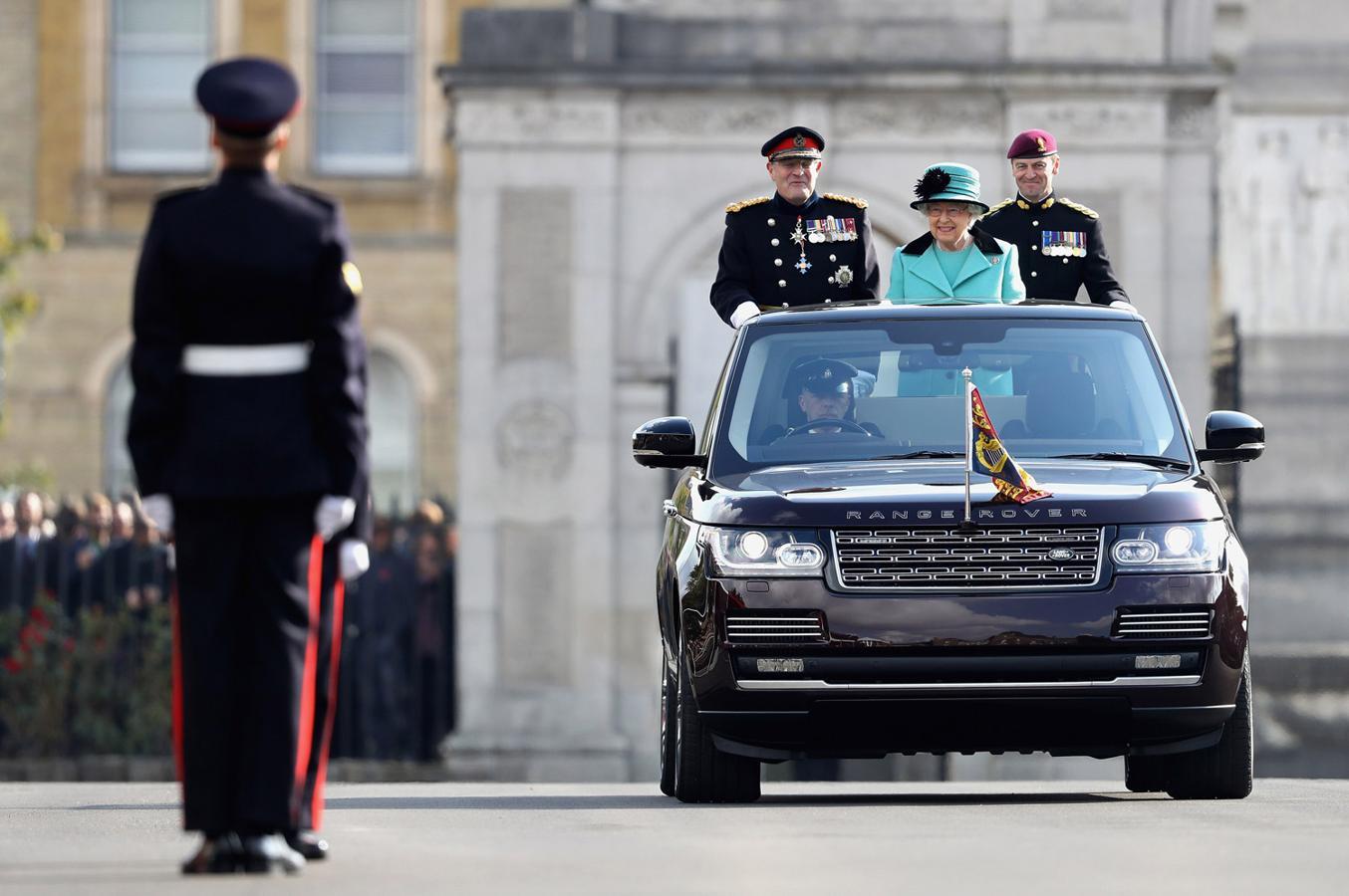 La Reina, en uno de sus coches oficiales, pasa revista a los cuerpos de seguridad británicos.