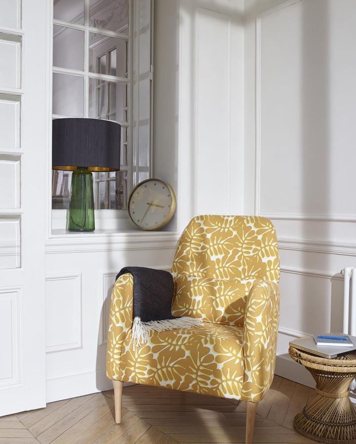 Una opción muy discreta pero de plena tendencia es la que ofrece Hábitat, con este sillón de inspiración retro con estampado de hojas en color ocre.
