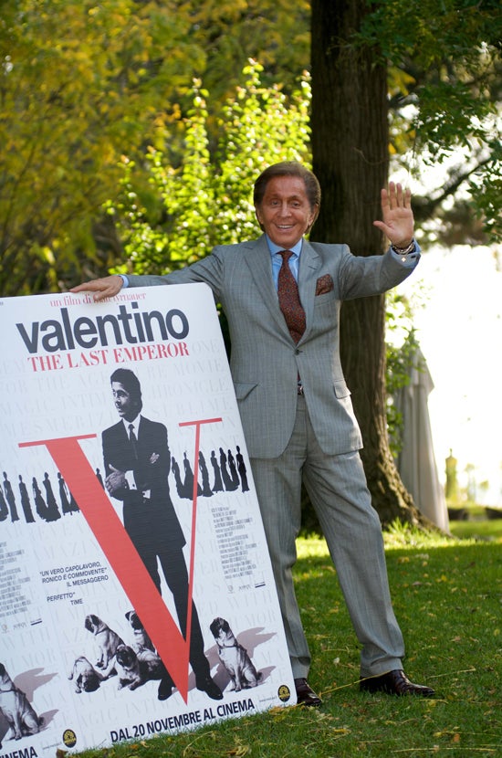El diseñador con el cartel del documental de su vide llamado 'Valentino: The last emperor'.