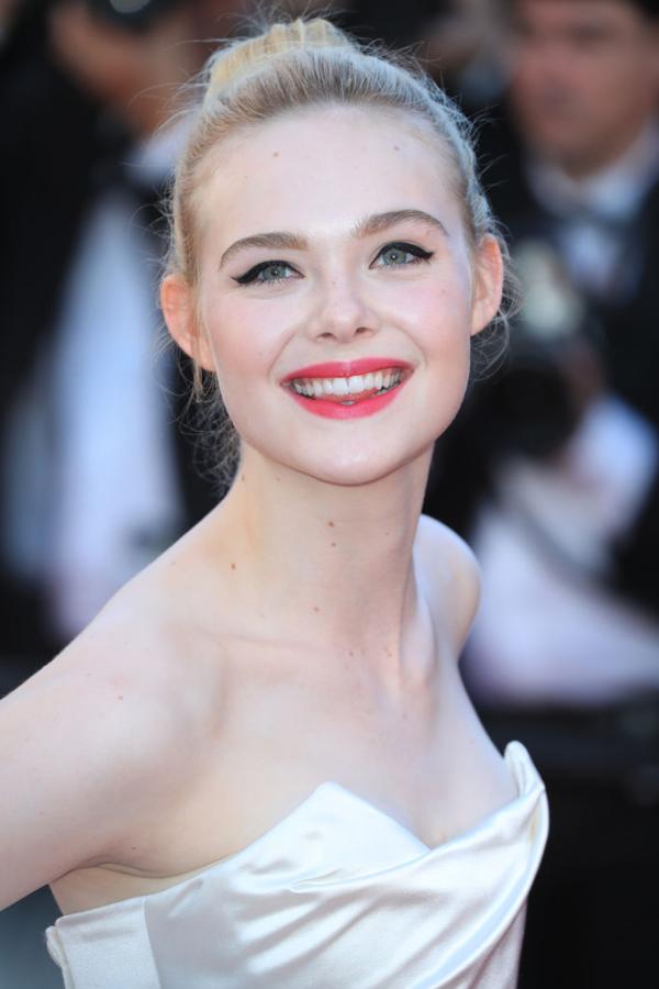 La nueva chica L'Oréal con moño de bailarina, eyeliner negro marcado y labios rojos.