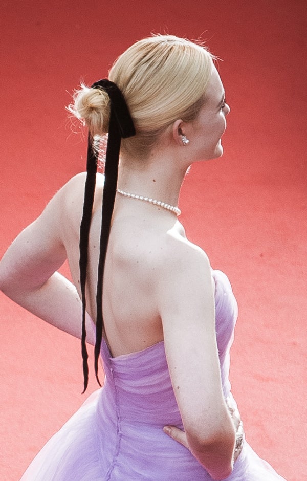 El clásico de moño de bailarina ligeramente despeinado y adornado con un lazo negro. Un detalle sencillo que le da un toque especial al recogido.