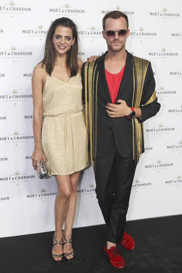 La pareja coordinó sus looks en dorado; ella se decantó por un minivestido color champán que combinó con sandalias y clutch plateadas mientras que su marido optó traje negro y zapatos rojos
