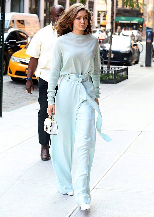 Gigi Hadid lució un pantalón 'paper bag' azul cielo confeccionado con tejido fluido que combinó con un top y unos botines blancos