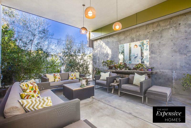 El estilo industrial juega con el gris como lienzo, y aporta notas de color en los espacios exteriores a través de los textiles y la vegetación natural.