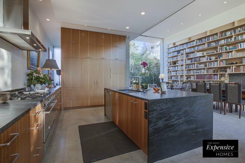 Como marca la tendencia de las últimas temporadas, la mansión de Emilia Clarke cuenta con una cocina abierta con isla que desemboca en el comedor principal, con su impresionante librería al fondo.